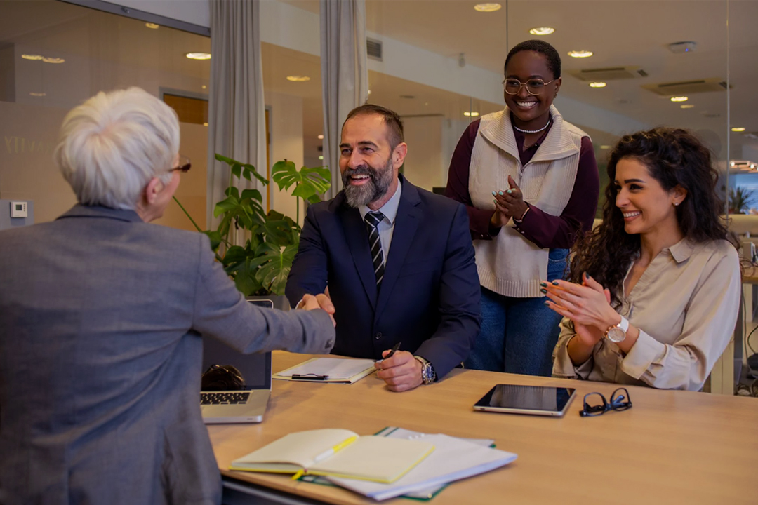 Business meeting with professionals shaking hands and smiling