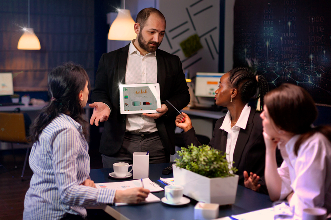 Team discussion with data presentation on tablet